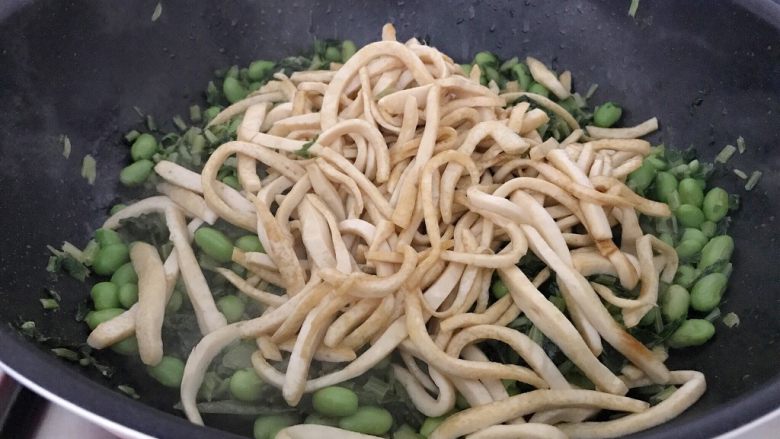 雪菜毛豆炒厚百叶,等毛豆和雪菜的水分煸炒接近收干时,毛豆和雪菜的鲜味也出来了,这时把厚百叶加进来,