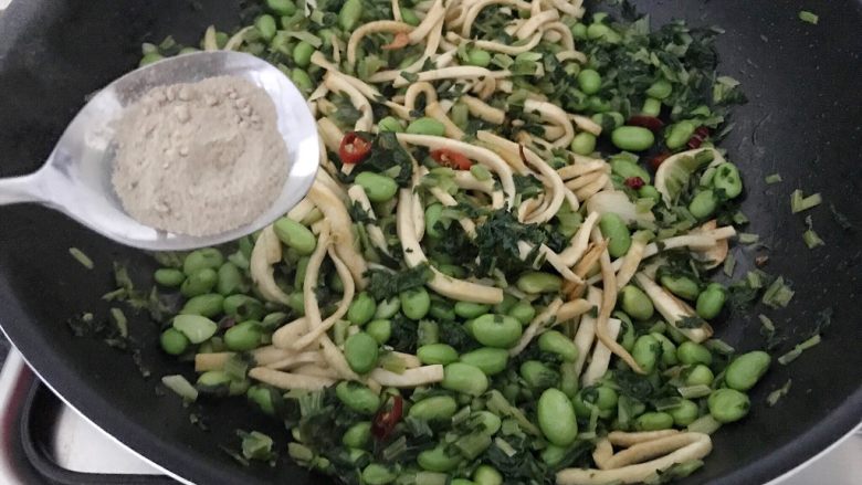 雪菜毛豆炒厚百叶,再加入白胡椒粉,煸炒均匀,