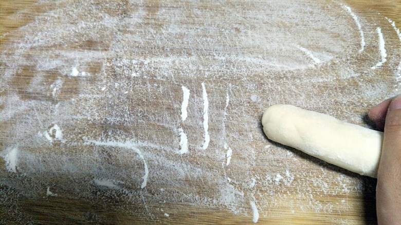 鲜美无比的香菇莲藕鲜肉包,案板上撒些面粉,取出醒发好的面团,搓成条。