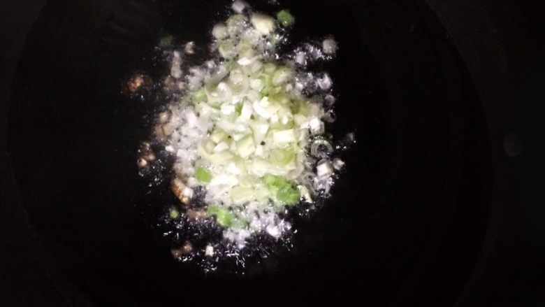 千层葱油饼,锅里倒入油,冷油直接放进芝麻。待油热后,放入葱白后慢慢拨动葱白和芝麻,使其受热均匀。(注意,防止被溅起的油烫伤)葱白稍微变黄,就可出锅备用。