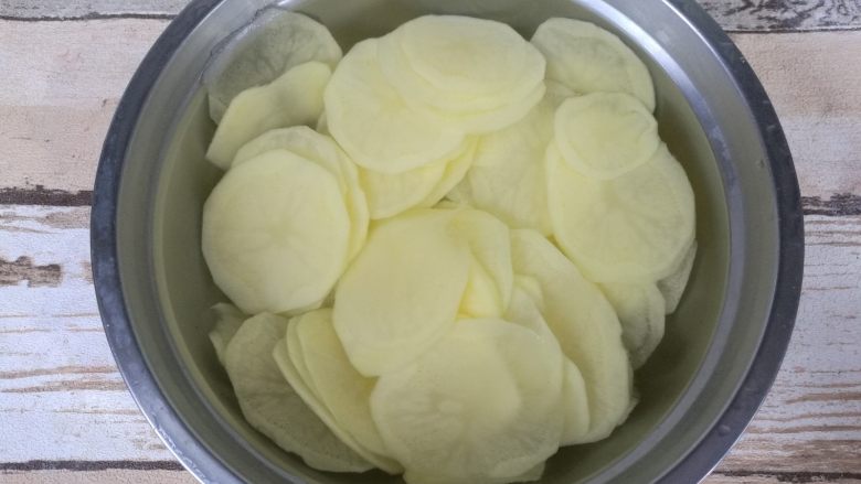 椒盐烤薯片,用清水冲洗四五遍,洗去淀粉质,最后放进清水中浸泡。