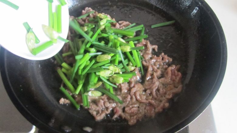 千张韭菜薹炒牛肉丝,牛肉丝煸炒变色后加入韭菜薹进去翻炒;