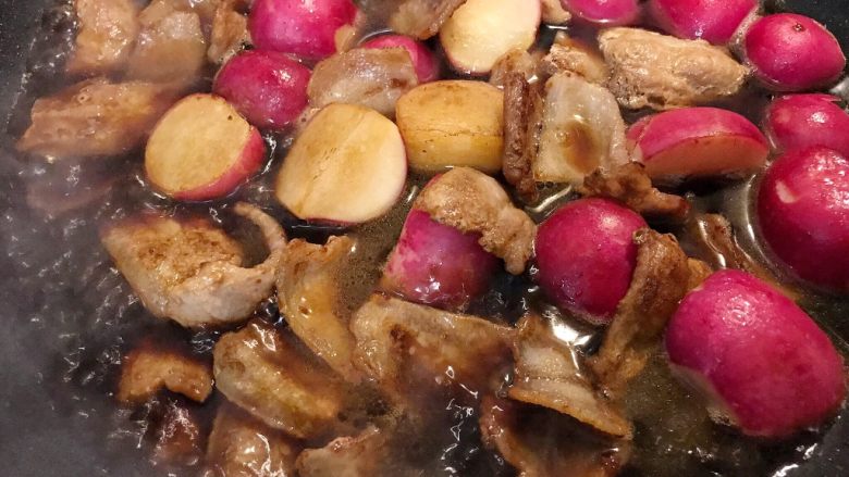 五花肉蒜烧小红萝卜,加清水莫过食材的一半,再把金葱铺在上面,