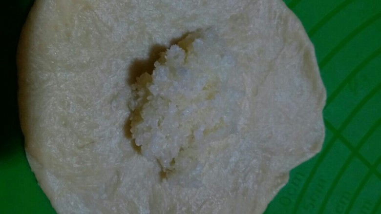 玫瑰花椰蓉面包,取一个面团擀开,包上椰蓉馅儿