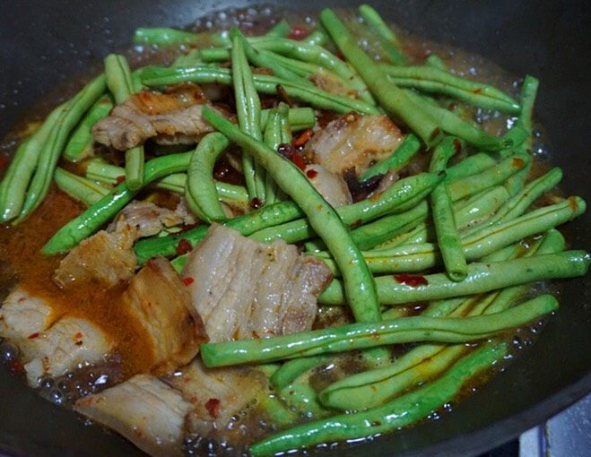 嫩豆角烧肉,炒出红油后下豆角,翻炒2-3分钟,倒入适量清水或者高汤烧熟