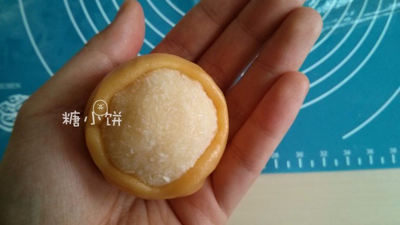 【椰蓉广式月饼】 ,用手把饼皮从下往上顺着椰蓉馅推