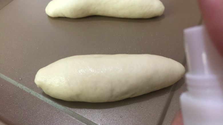 麦香软欧香肠包,11. 码在烤盘上,用喷壶喷上少许水
