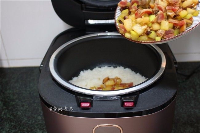 葫芦瓜腊肠冬菇焖饭,铲起锅中的食材,倒进电饭锅内