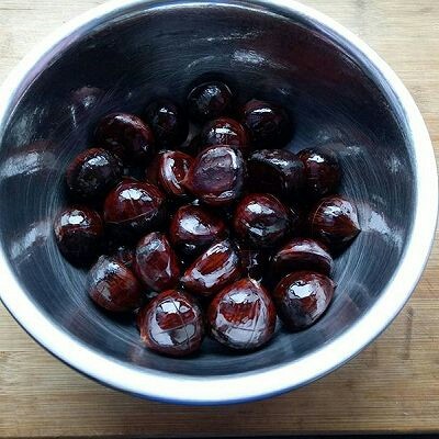 糖烤栗子,把切好花刀的栗子放入一个小盆里,加入适量油,搅拌均匀使每一粒栗子都沾上油
