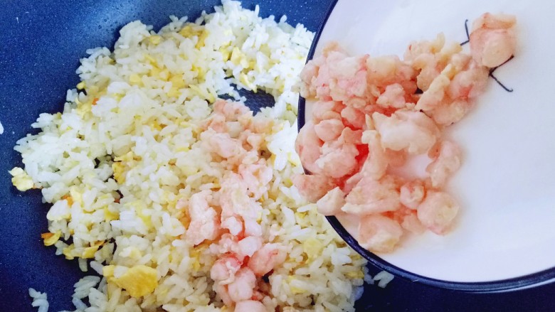 虾仁黄金炒饭,加入炒过的虾仁,翻炒均匀。