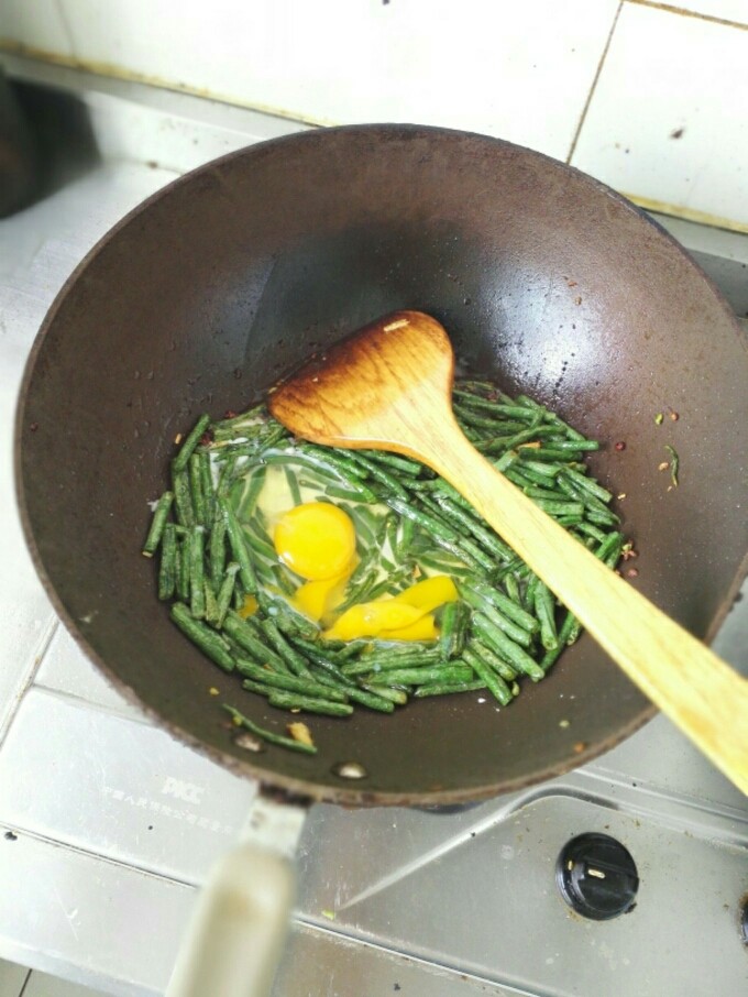 豆角炒蛋,待豆角炒至变色，打入鸡蛋（直接打鸡蛋就行，不用事先搅拌），翻炒