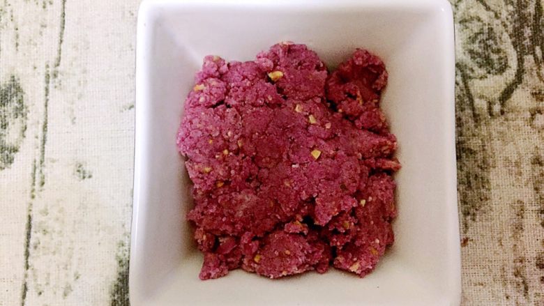 紫薯奶酥粒豆沙吐司,制作奶酥粒:将材料中的黄油和糖用刮刀压拌,直到两者完全融合并且质地松软时加入其他粉类和坚果碎拌匀即可,盖保鲜膜密封,冰箱冷藏待用。