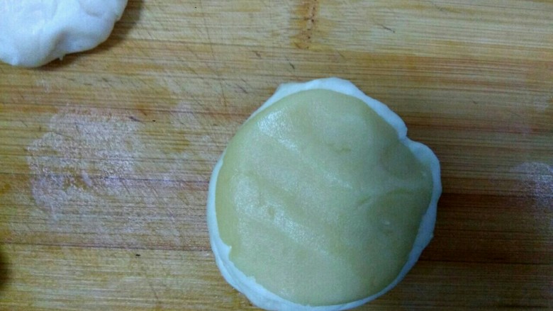 豆沙烧饼,拿一个面团压平，包上油酥，收口向下