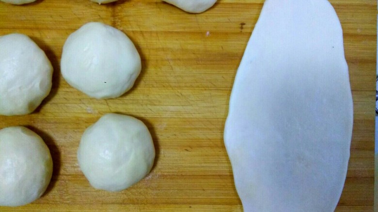 豆沙烧饼,拿出一个包好油酥的面团，擀成牛舌状