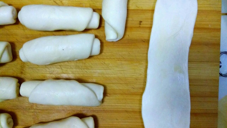 豆沙烧饼,拿出一个卷好的卷儿顺着擀成牛舌状