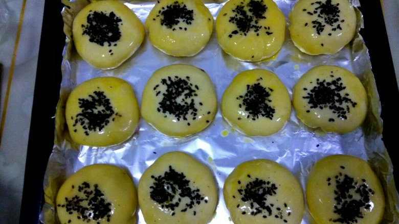 豆沙烧饼,撒上<a style='color:red;display:inline-block;' href='/shicai/ 668'>黑芝麻</a>，放入烤箱。中层，上下火，200度，30分钟（烘烤时注意观察，根据自家烤箱的不同特点随时调节。我做的大了，所以烘烤时间长）