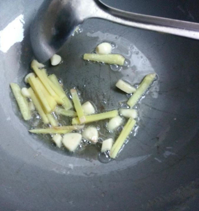 学会鱼肉的这种新吃法,吃一口就停不下来!,锅烧热,加入适量的植物油,油烧热后下蒜片跟姜一同下锅爆香。