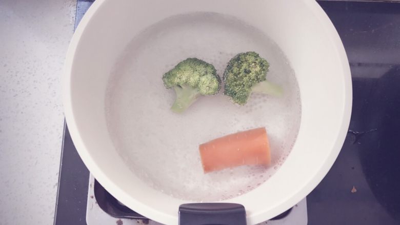 奶香玉米浓汤 宝宝辅食,锅里烧水,水开后将洗净的胡萝卜和西兰花倒入锅中