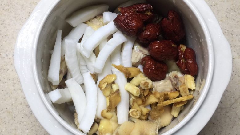 沙参玉竹椰子鸡汤(附开椰子方法),炖锅里放入鸡肉,红枣,椰子肉,沙参,玉竹。