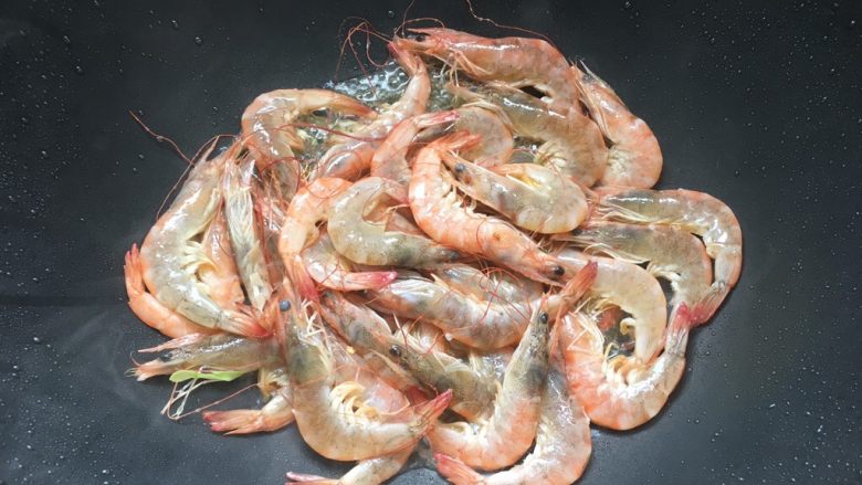 蒜香油焖基围虾,利用底油,倒入虾大火煸炒至虾全部变红。