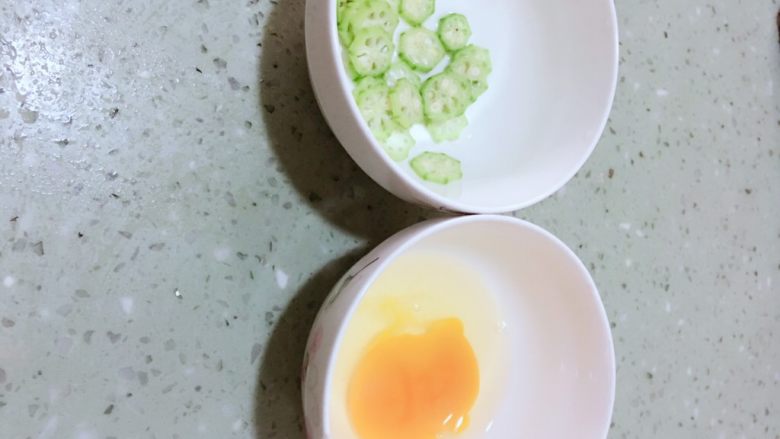 秋葵蒸嫩蛋 宝宝辅食10M+,将鸡蛋打入碗中,秋葵洗净切成薄片