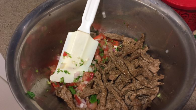 墨西哥风味牛肉沙拉,炒好的牛肉丝加入拌好的蔬菜里面,拌匀。