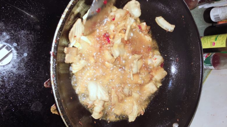 芹菜豆干炒回锅肉,加入两勺红油豆瓣酱,蒜瓣继续翻炒