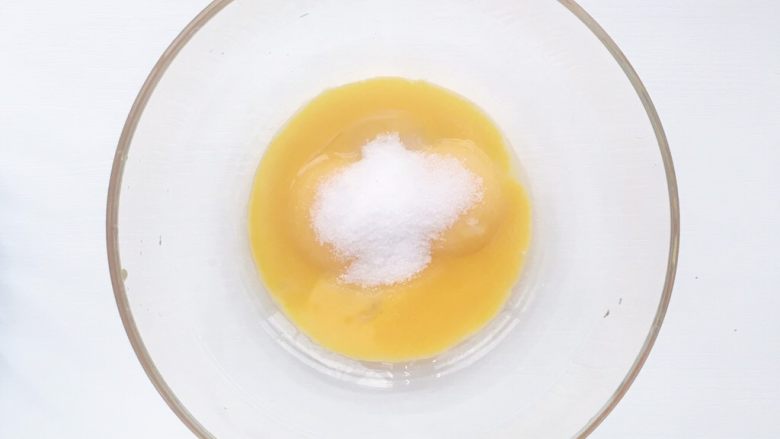 电饭煲蒸蛋糕,
食材处理二:蛋黄糊步骤
在盛有蛋黄的容器加入白砂糖30克