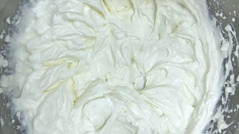 奶酪西瓜蛋糕,制作奶油奶酪霜。奶油奶酪提前放至室温,加入糖粉打发至顺滑,滴入几滴柠檬汁,加入淡奶油,继续打发,成为酸甜又润滑的奶油奶酪霜。