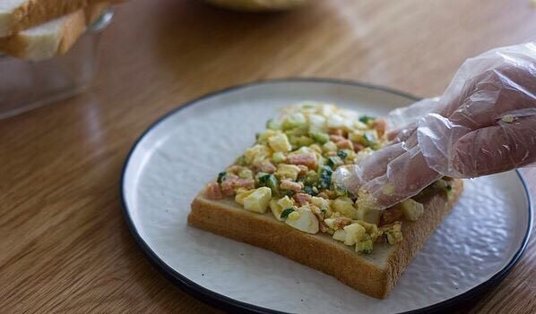 快手美味鸡蛋三明治,取一个面包片，把馅料放在上面，压实以后再加一层。可以加上喜欢的<a style='color:red;display:inline-block;' href='/shicai/ 121'>生菜</a>。
