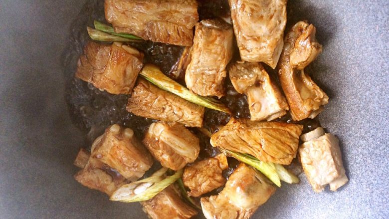 中餐厅之糖醋排骨,放入调好的料汁继续炒,放葱段姜片。