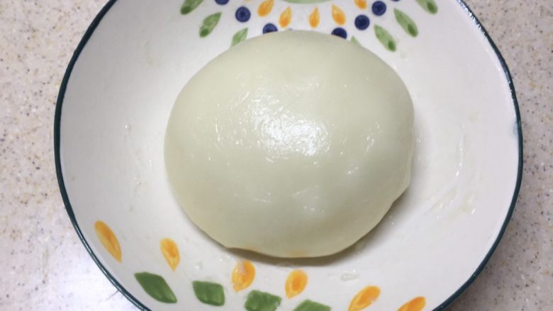冰皮月饼(附豆沙做法),蒸好的冰皮搅拌放至微热不烫手。戴上一次性手套揉成光滑的面团,揉到什么程度就好像你的耳垂那样的柔软度就可以了。