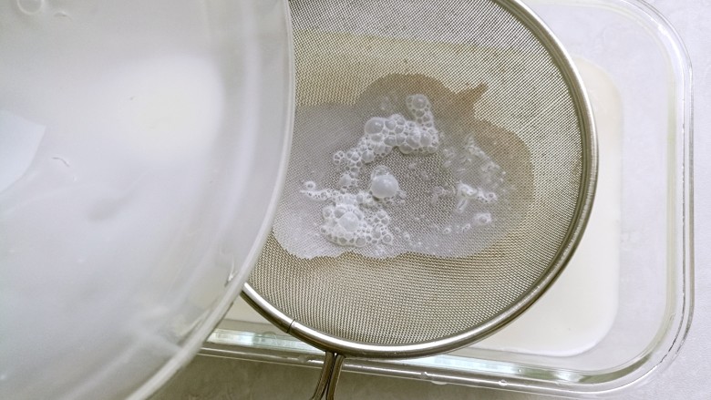芋圆鲜奶冻,取一个方形容器,将混合物过一下筛,这样可以去除液体中的浮沬。