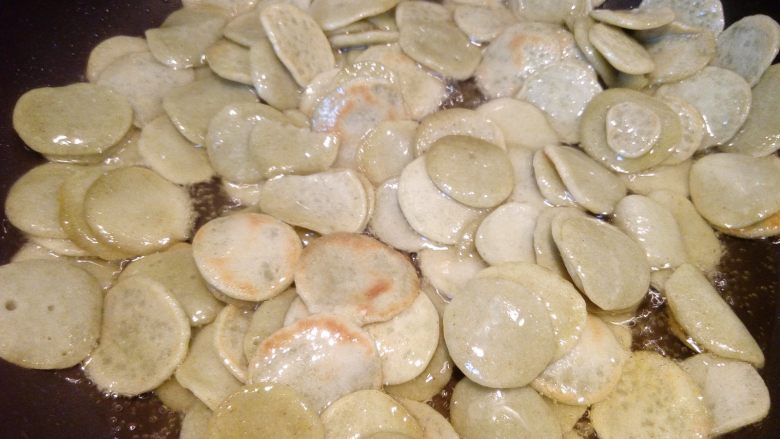 麻辣椒盐豆饼,倒入豆饼以中火炸制,小心油溅出烫到。