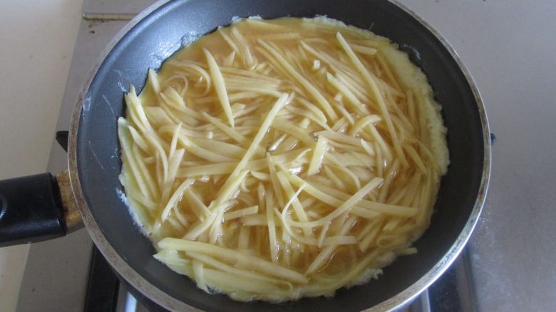 土豆丝饼,热锅凉油, 倒入土豆丝蛋液;
