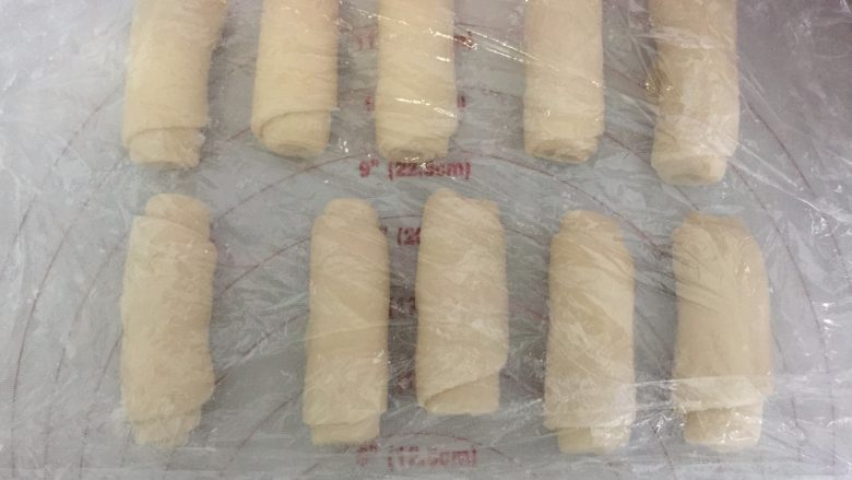 芝士大虾鲜肉月饼,卷起来,卷好之后,收口朝上,盖上保鲜膜,松驰15分钟