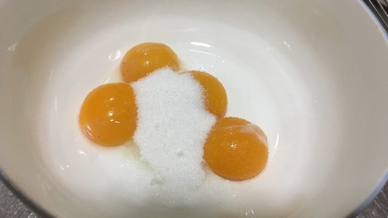 小白菜无奶戚风蛋糕,蛋黄中加15g细砂糖,用手动打蛋器打散至砂糖融化。