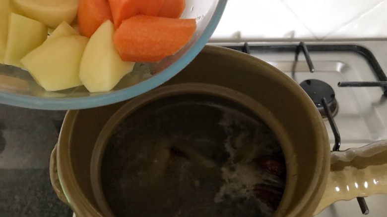 肇实灵芝片煲肉骨汤,当汤锅煮有1个多小时后,把胡萝卜和土豆加进来,再继续煲上30分钟,