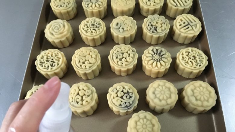 广式蛋黄豆沙月饼,这时烤箱上下火180度预热5分钟,在预热期间先在月饼表面喷上水