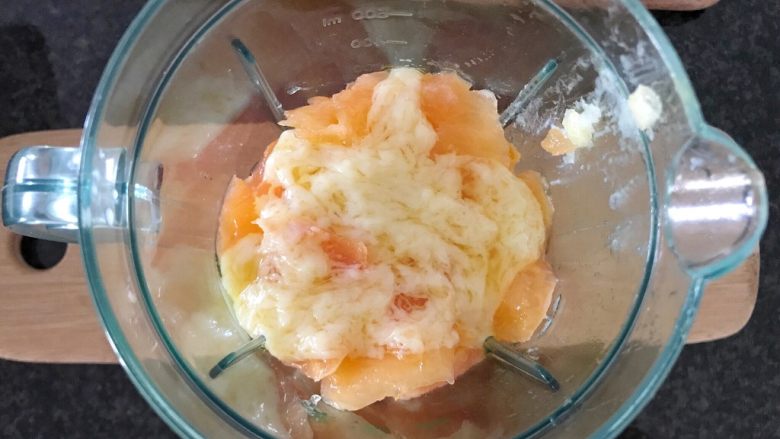 牛油果木瓜思慕雪,先把木瓜加进搅拌机里加2小勺牛奶巧克力,