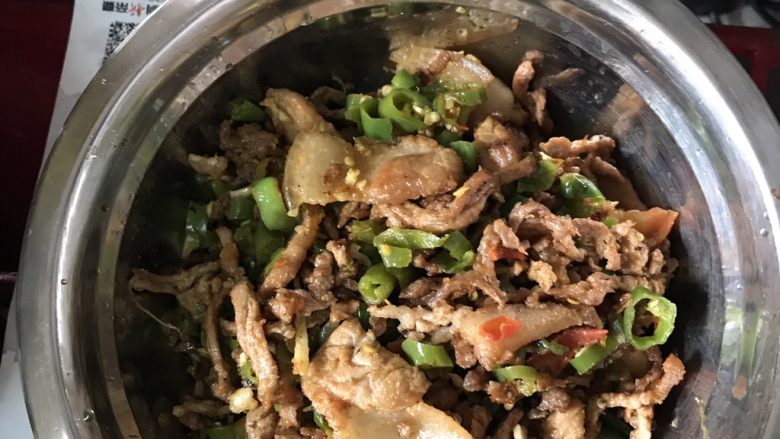 青椒番茄五花肉炒肉丝,剩下的油把青椒蒜末姜丝放在炒锅里翻炒20分钟。后放番茄酱炒。猪肉丝和五花肉放在炒锅里面翻炒25分钟。放上 老抽 盐 鸡精 上盘即可。