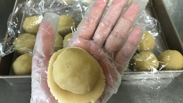 广式莲蓉月饼(自制内馅),月饼皮按压扁平,馅料放入面皮中