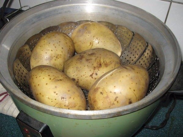 孜然土豆,土豆用电饭锅蒸至8分熟。土豆用一杯水下去蒸至跳起,就大约是8分熟,里面还会有点微硬。(如果不用电饭锅,可以水煮十几分。)