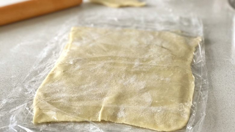 牛角可颂,将长方形的酥皮擀成合适的大小,用保鲜膜隔开,中间撒上面粉以免粘连,直接放入冰箱冷冻,冷冻可保存三四个月。