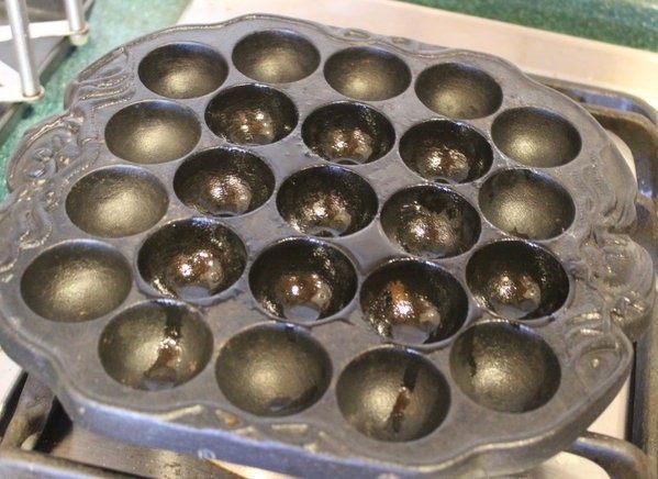 土豆章鱼烧,将章鱼烧铁盘放上瓦斯炉上,中火烧热,抹上一些油。