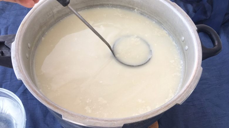 手工自制豆腐~纯天然无添加,用小勺舀半勺胆巴水沿豆浆上面打转,打7~10回转内把胆巴水加入豆浆中,注意看豆花形成。