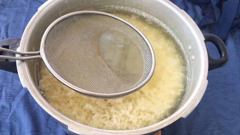 手工自制豆腐~纯天然无添加,这个时候用浓密一点的漏勺,轻轻下压豆花,让豆花更好凝固在一起!把多余水份用勺子舀出来!