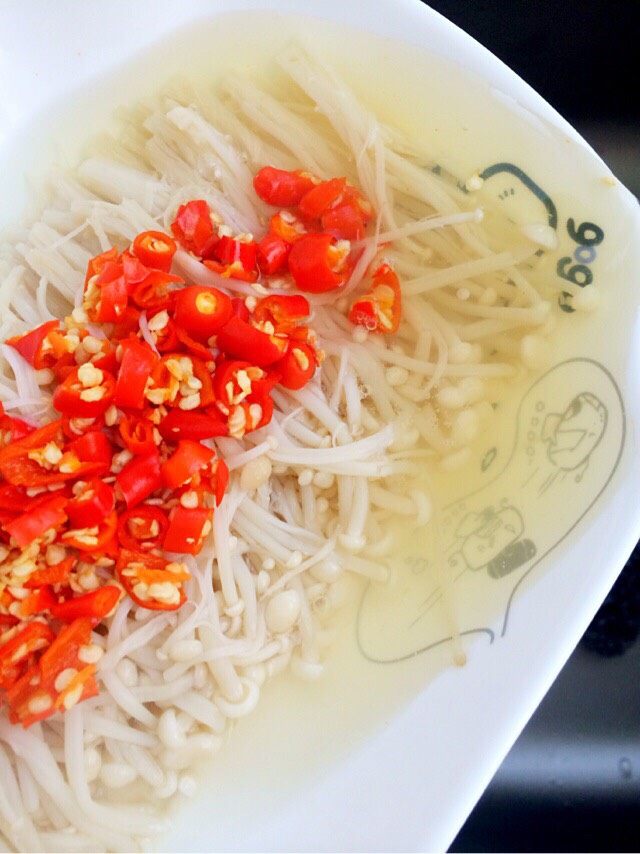 椒香金针菇,五分钟后,金针菇蒸好,拿出来倒掉盘子里的水