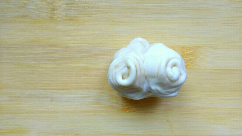 肉馅烧饼,拿起一个小卷儿，从两端往上拉起