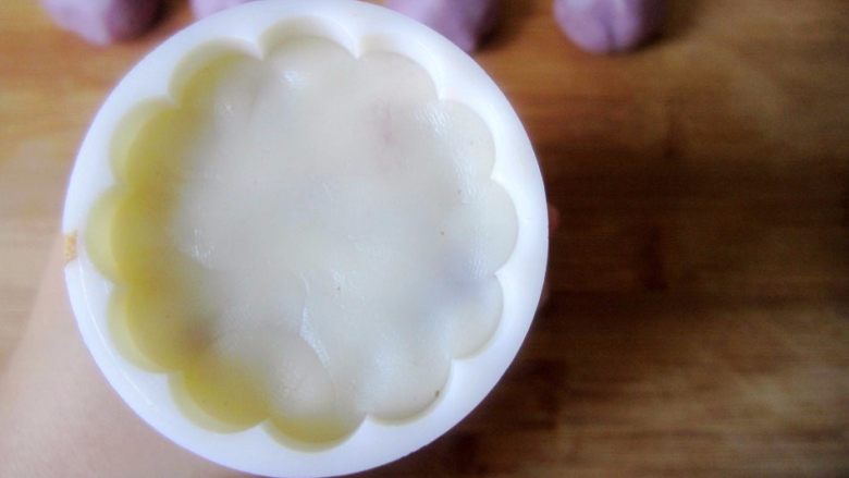 低糖低油【紫薯冰皮月饼】,再取一个步骤8包好的月饼坯压入步骤9压过紫色面团的模具中,将底部压平